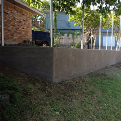 Retaining Wall Dallas TX A cement retaining wall on a residential property.