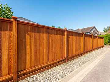 A long wood privacy fence surrounding a home.